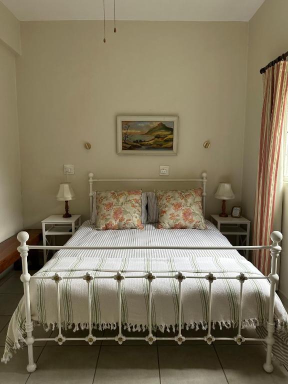 a white bed in a bedroom with two lamps at Private Garden Studio Cottage with BBQ 10 min walk to Pennington Beach in Pennington