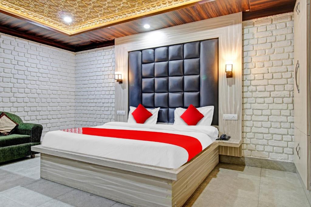 a bedroom with a large bed with red pillows at Hotel O THE HOTEL Oshin Hotel & Restaurant in Srinagar