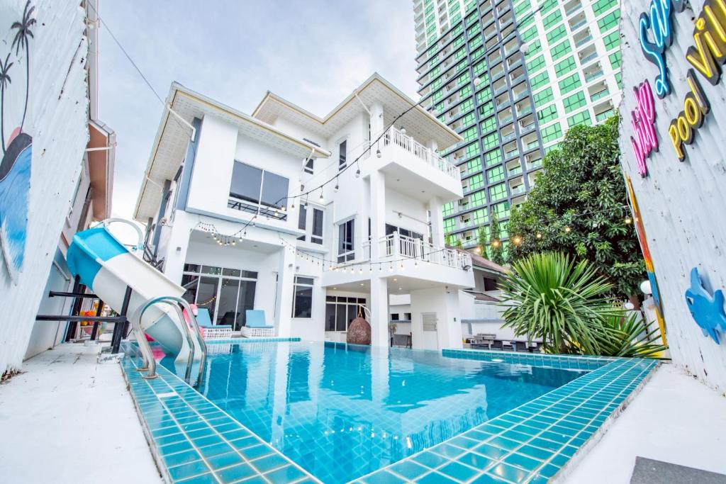 a pool in front of a house with a water slide at White Sand Pool Villa Pattaya in Jomtien Beach