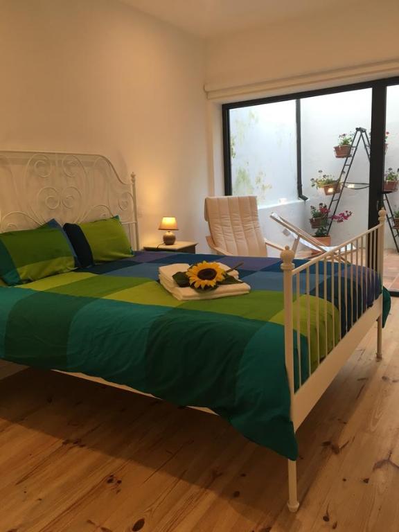 1 dormitorio con 1 cama con edredón verde en Casa dos Pátios, en Aveiro