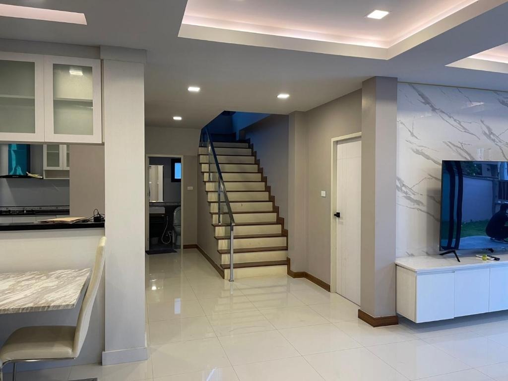 - un salon avec un escalier et un aquarium dans l'établissement The Lake Cozy 3BR Villa Pattaya, à Ban Huai Yai