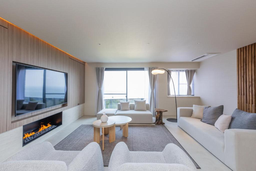 a living room with white furniture and a fireplace at Vast Bleu IWAYA in Awaji