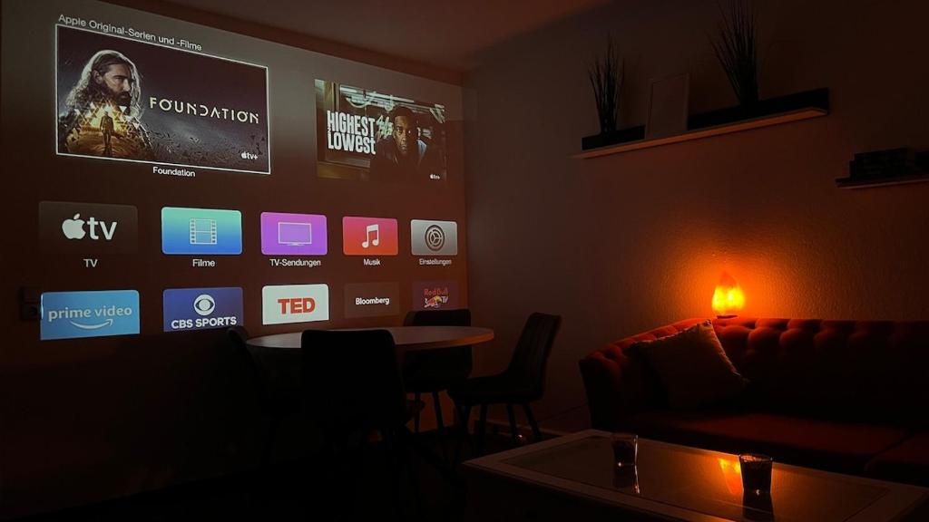 a living room with a couch and a tv on the wall at Gemütliche Wohnung, Heimkino, Couch & Küche in Siegen