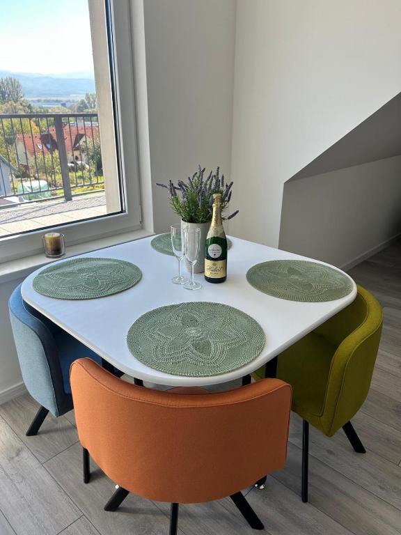 a table with four chairs and a bottle of wine at Apartman Bojnice Kúpele in Bojnice