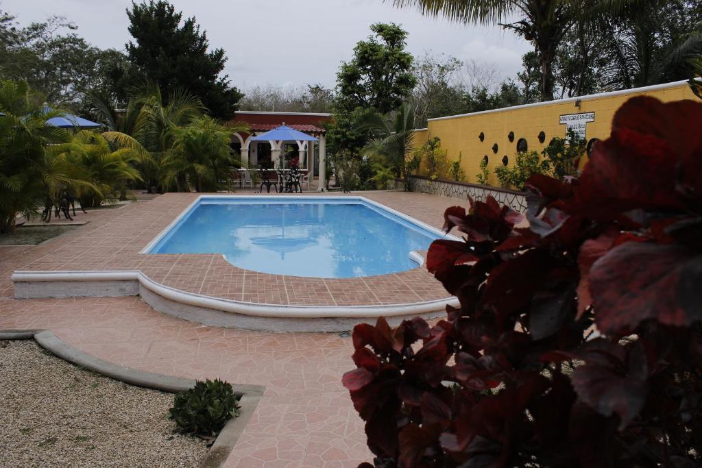 a swimming pool in a yard with a house at Posada Ya´ax Ich in Izamal