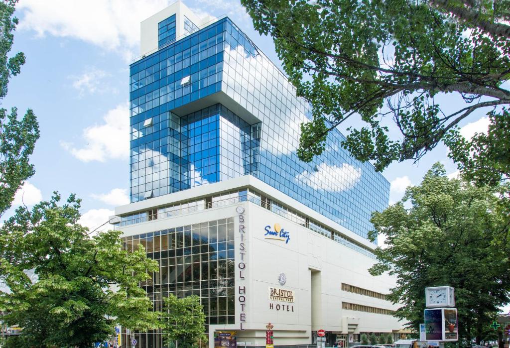 a tall building with a sign in front of it at Bristol Central Park Hotel in Chişinău