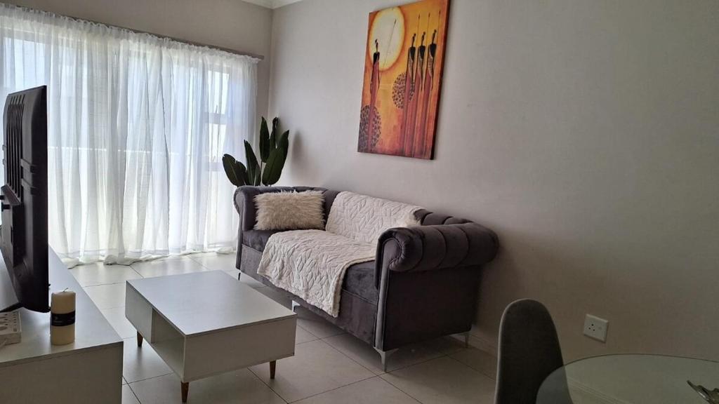 a living room with a couch and a table at The Perfect Luxury Space at 93 on new in Midrand