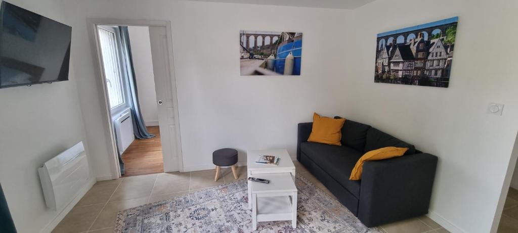a living room with a couch and a table at Appartement lumineux -terrasse au cœur de Morlaix in Morlaix