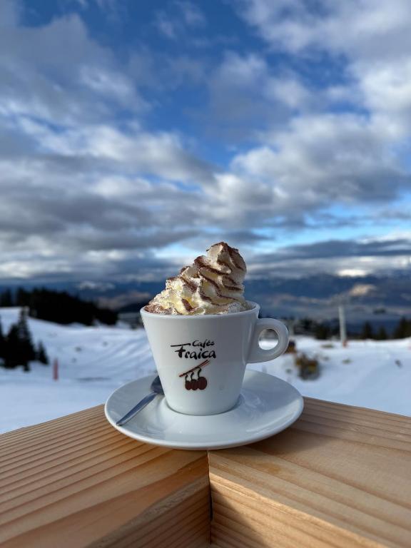 a cup of coffee sitting on top of a wooden table at Appartement au pied des pistes à Roche-Béranger in Chamrousse