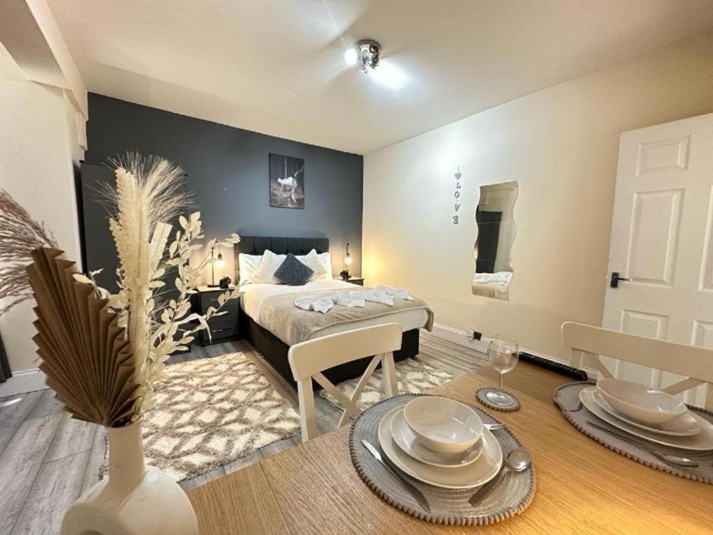 a bedroom with a bed and a dining room with a table at Edgware Road Beautiful Family Apartment in London