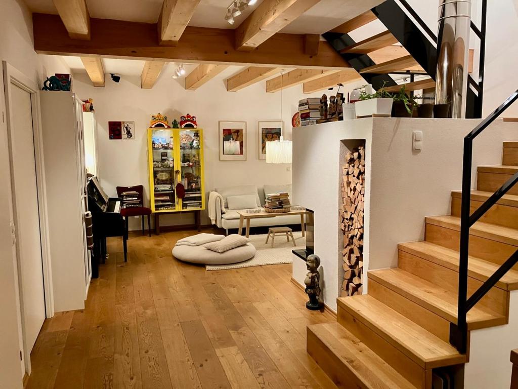 sala de estar con escalera y mesa en The Wurmstein House - Contemporary Mountain Home, en Bad Goisern