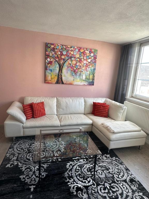 ギュンツブルクにあるMarktplatz Ferienwohnungの白いソファと絵画が飾られたリビングルーム