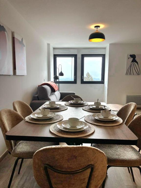 Le duplex في ليز أنغلز: طاولة وكراسي في غرفة معيشة بها طاولة وكراسي