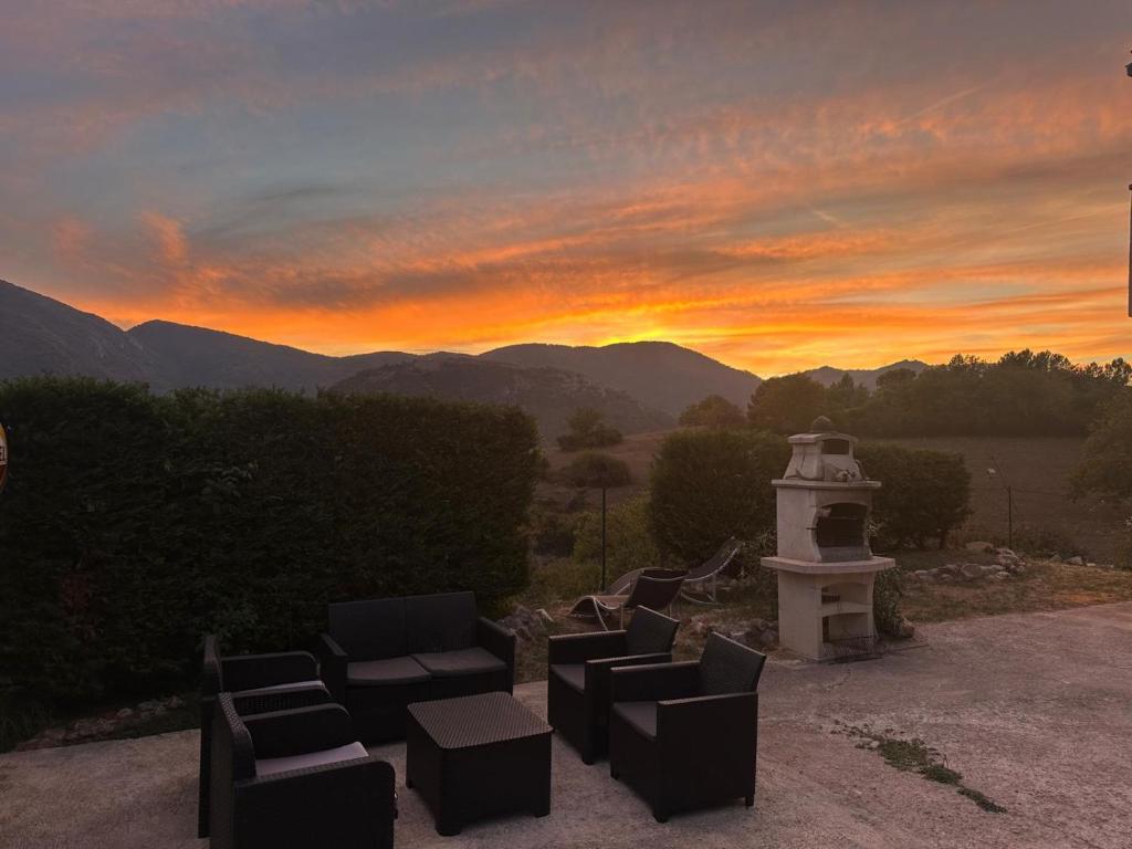 a group of chairs and a tower with a sunset at Charming Mountain Escape in Sospel, Perfect for Nature Lovers in Sospel