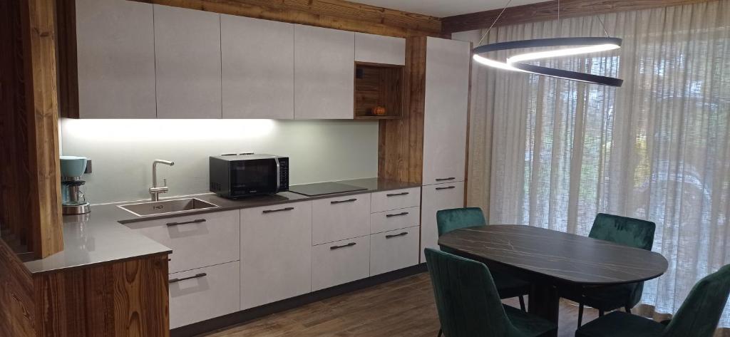 een keuken met een tafel en stoelen en een eetkamer bij Chalet Radola in Campitello di Fassa