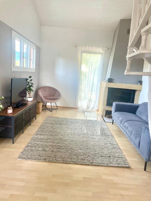 a living room with a blue couch and a rug at Comfortable apartment a stone's throw from Nyon in Duillier