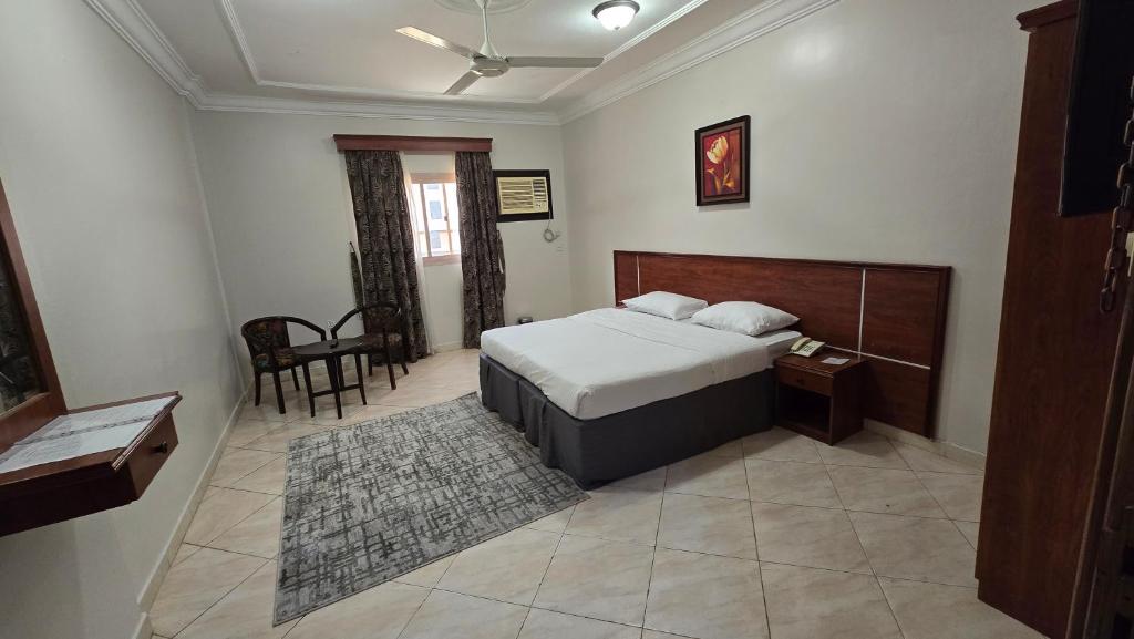 a bedroom with a bed and a table and a chair at درة الصالحين للشقق المخدومة in Makkah