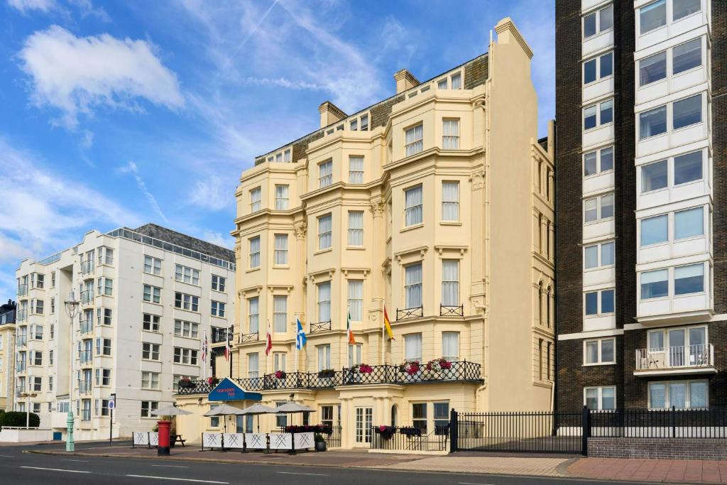 a tall yellow building with flags in front of it at Four Points Flex by Sheraton Brighton Seafront in Brighton & Hove