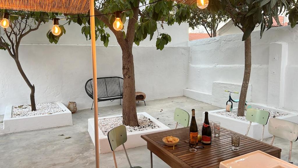 a table with two bottles of wine and two trees at Lemon and avocado house in Portimão