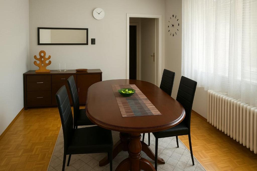 une table à manger avec des chaises noires et une salle à manger dans l'établissement Apartman Centar Banja Luka, à Banja Luka