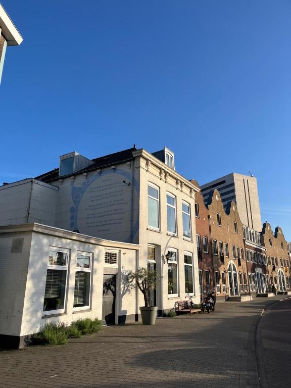 ein weißes Gebäude an einer Straßenseite in der Unterkunft Schie2Be in Schiedam