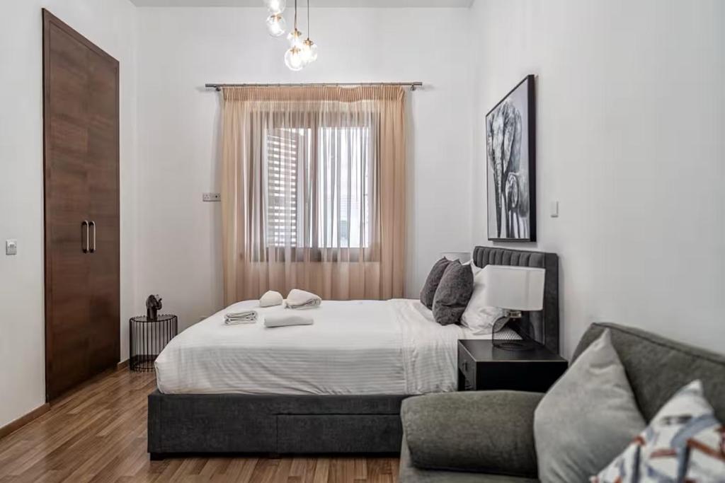 una camera da letto con un letto grande e un divano di Cozy house city center in Limassol a Limassol