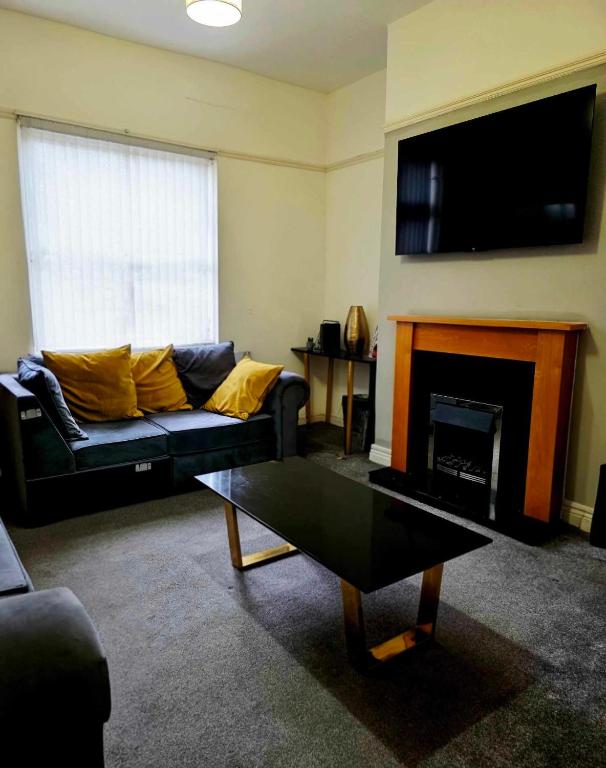 a living room with a couch and a fireplace at Oge's House in Bradford