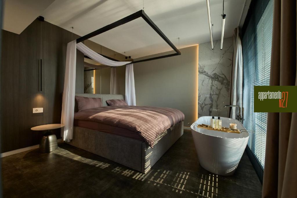 a bedroom with a bed and a bathtub and a bed and a bathtub at Appartamento N in Iaşi