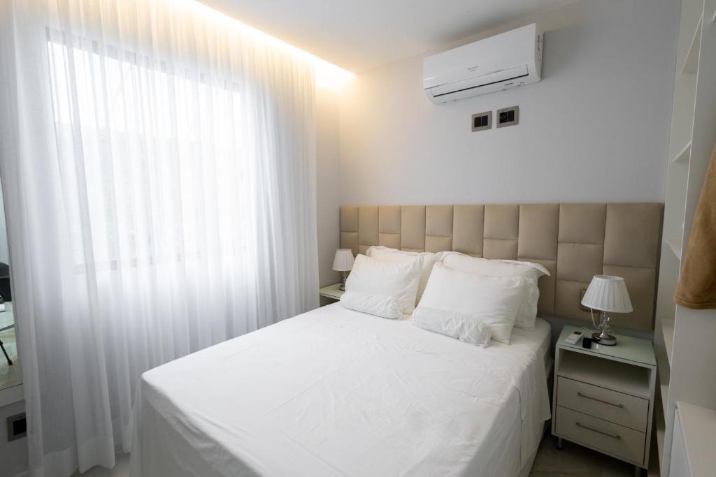 a bedroom with a white bed and a window at Studio Praia do jardim 1 208B in Angra dos Reis