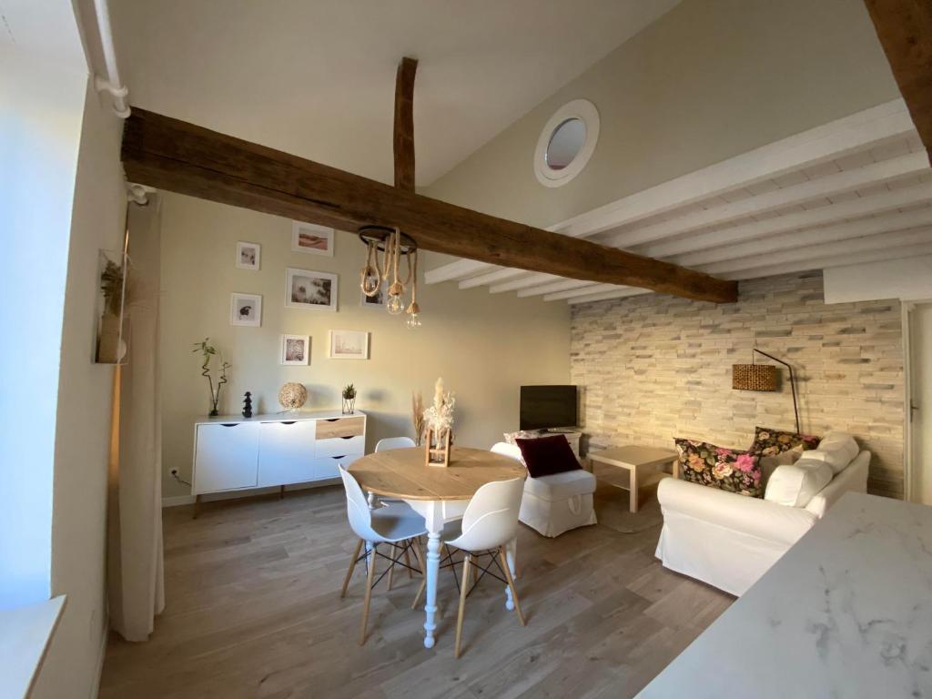 a dining room and living room with a table and chairs at Charmant appartement centre ville de Castres in Castres