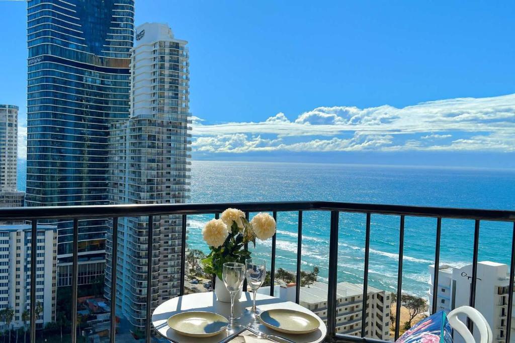 a table with a vase of flowers on a balcony at Top Ocean View Artistic Apt in Gold Coast