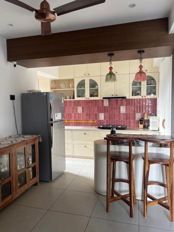 a kitchen with a black refrigerator and a table at Vintage home in Ahmedabad
