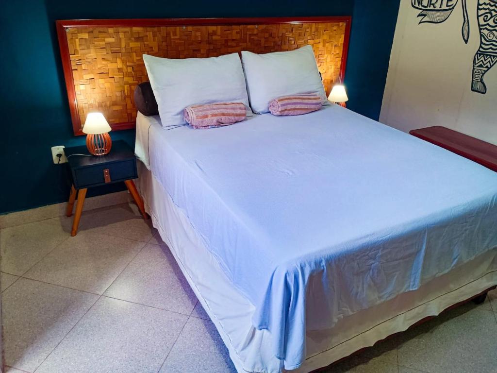 a bedroom with a large white bed with two pillows at Casa Marajoara in Soure
