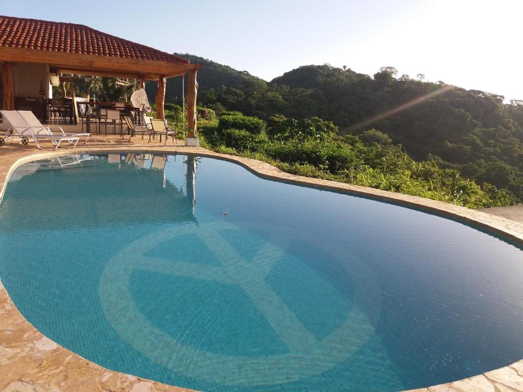 a large swimming pool in front of a house at Hotel Peace & Lodge in Sámara