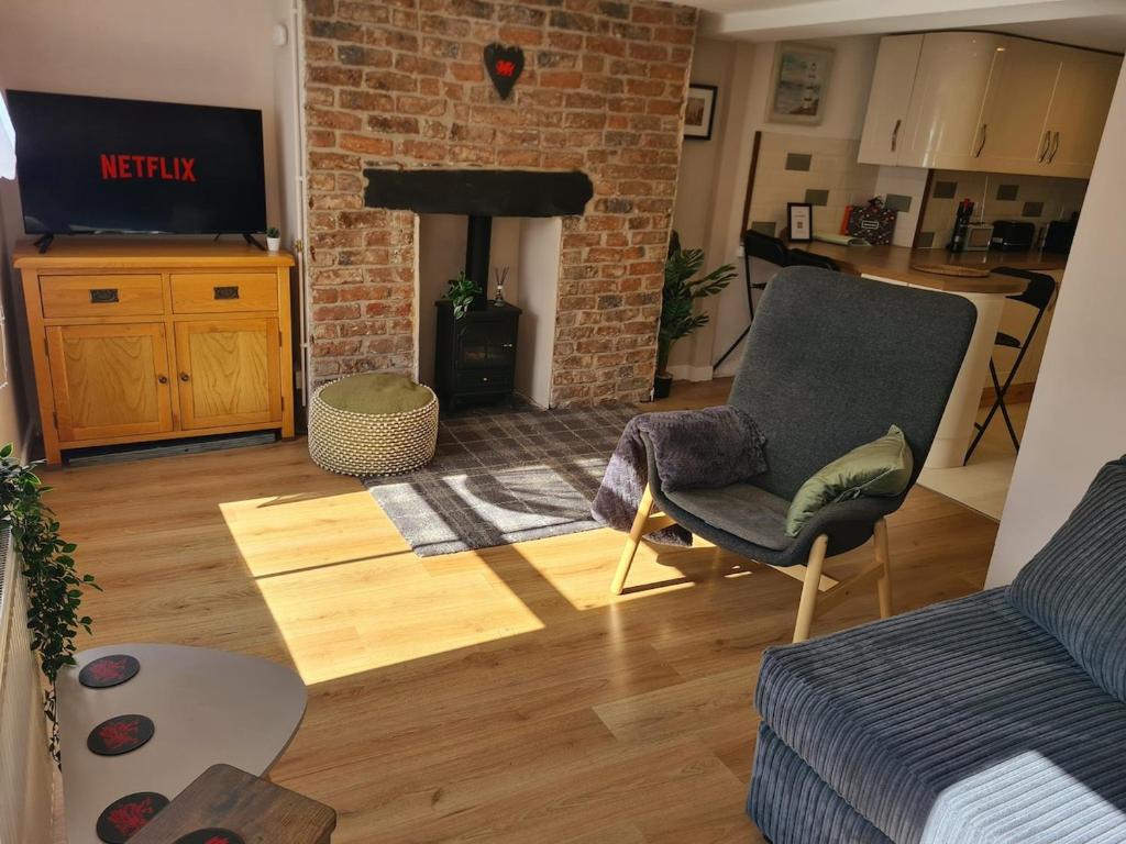 a living room with a couch and a fireplace at Cosy Townhouse Within Caernarfon's Old Town Walls in Caernarfon
