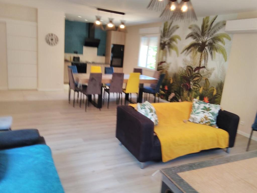 a living room with a couch and a dining room at Le Grand Tilleul in Draguignan