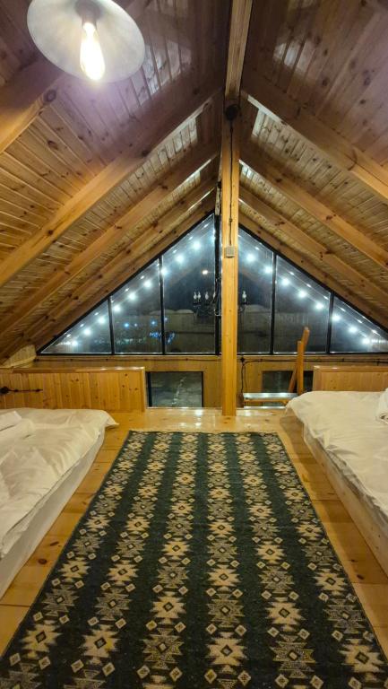 a large room with two beds and a large window at Banoja Twins in Kutaisi