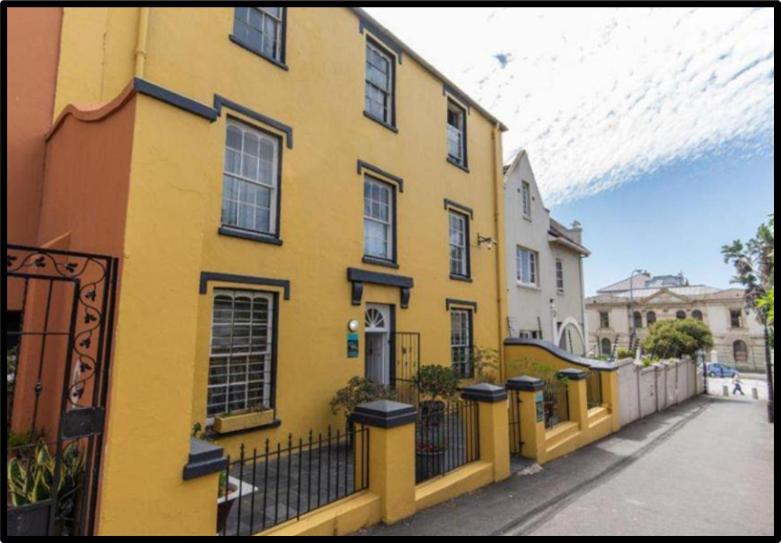 a yellow building on the side of a street at 1 Cora Terrace Accommodation in Gqeberha
