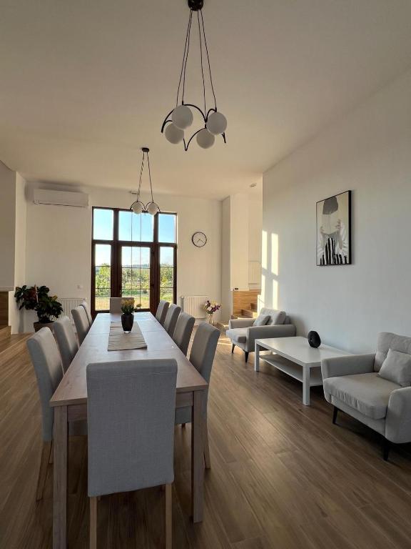 a living room with a dining room table and chairs at Colt de Apuseni Guesthouse in Curăţele