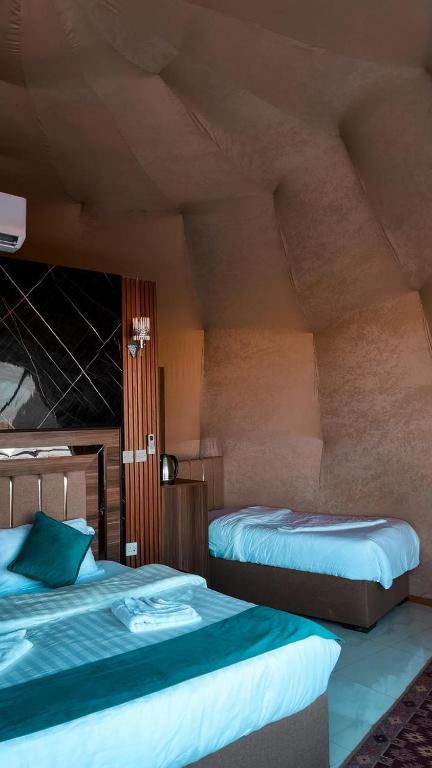 a bedroom with two beds in a room at Milky Way Luxury Camp in Wadi Rum