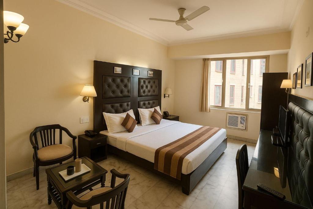 a bedroom with a bed and a chair and a window at Hotel Perfect, Karol Bagh, 2 mins walk from metro station in New Delhi
