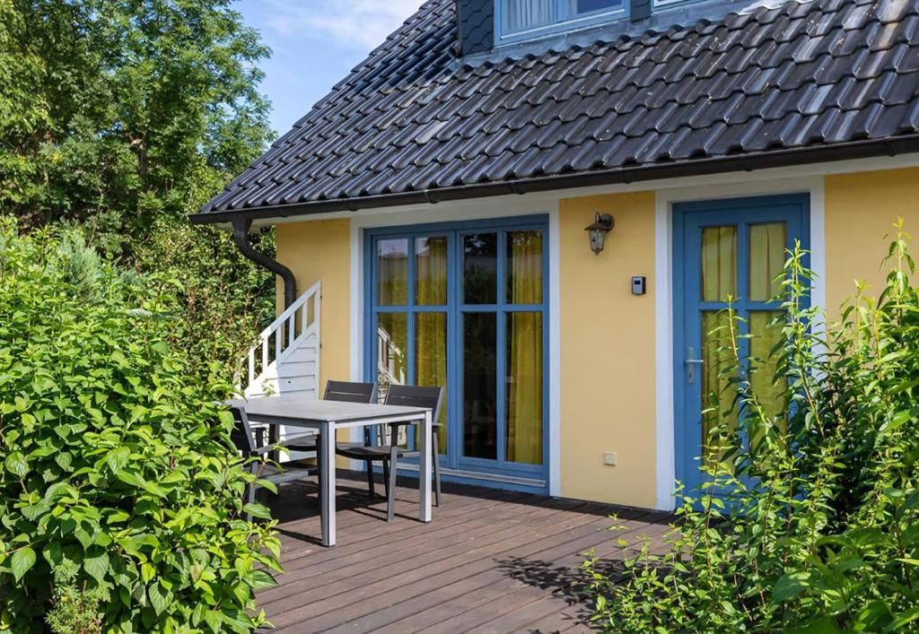 eine Holzterrasse mit einem Tisch und Stühlen auf einem Haus in der Unterkunft Ferienhaus für 3 Personen  2 Kinder ca 60 m in Neuenkirchen, Ostseeküste Deutschland Rügen in Neuenkirchen