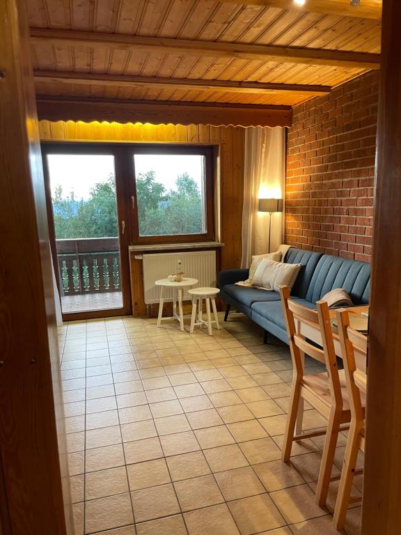 a living room with a blue couch and a table at Modernes Top Apartment mitten im Bayerischen Wald + WLAN kostenfrei in Schöfweg