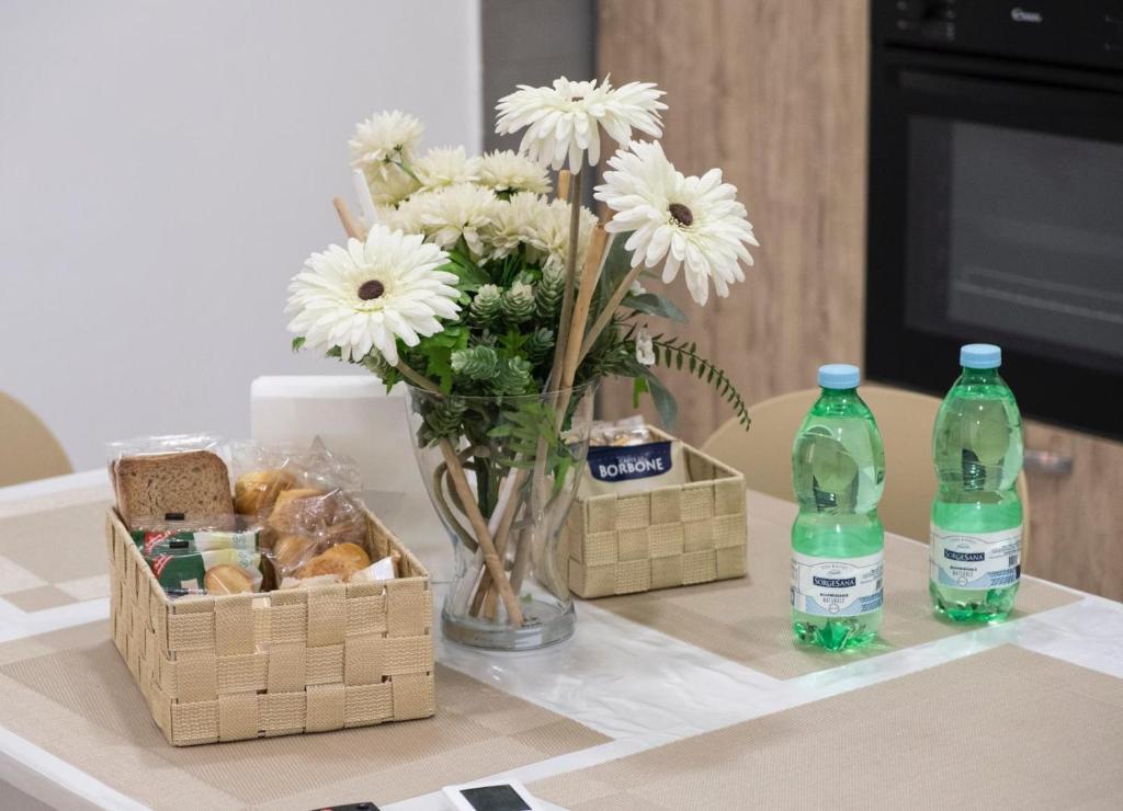 a table with a vase of flowers and two bottles of water at Micky House in San Marzano sul Sarno