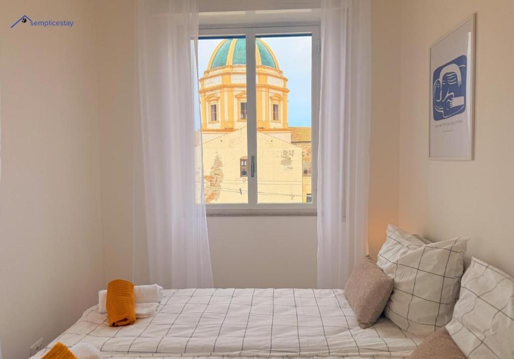 una cama en una habitación con ventana en Balconi di Sicilia by Ferdinando, en Trapani