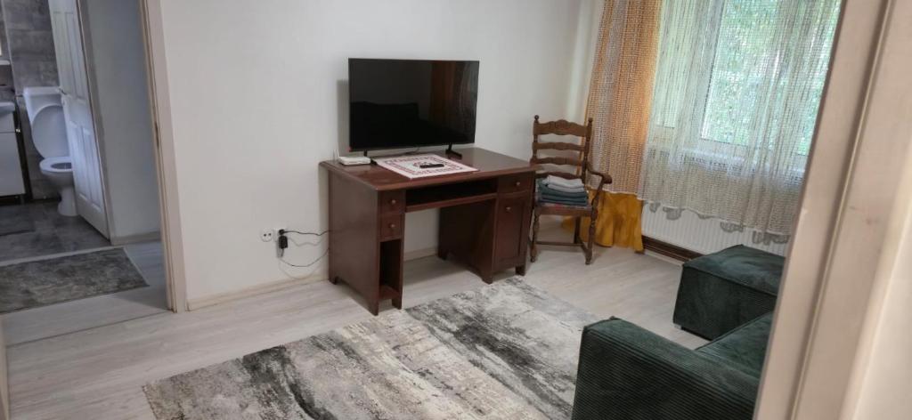 a room with a desk with a television and a chair at LCB Apartments C04 in Târgu-Mureş