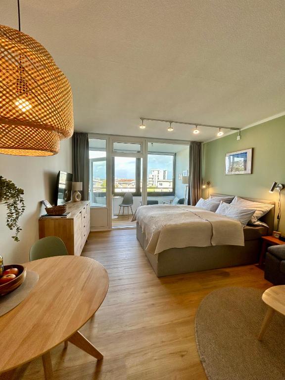 a bedroom with a large bed and a living room at Apartment Hygge mit Ostseeblick in Wendtorf