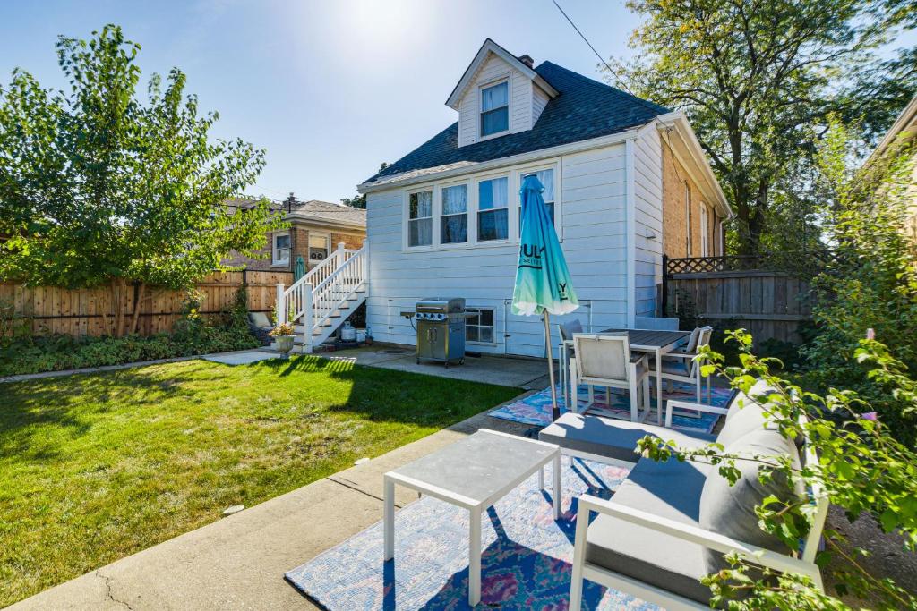 a yard with a house with an umbrella and chairs at Logan Square Urban Oasis: 2 Mi to Local Hotspots! in Chicago