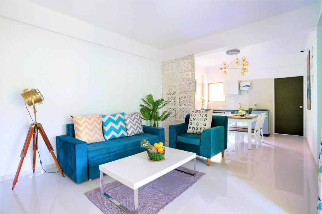 a living room with a blue couch and a table at White Pearl by Leo Homes - 2BHK near Anjuna Beach in Anjuna