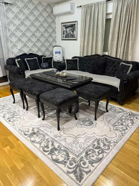 a living room with a black couch and a table at Luxury Heaven Vogošća in Vogošća